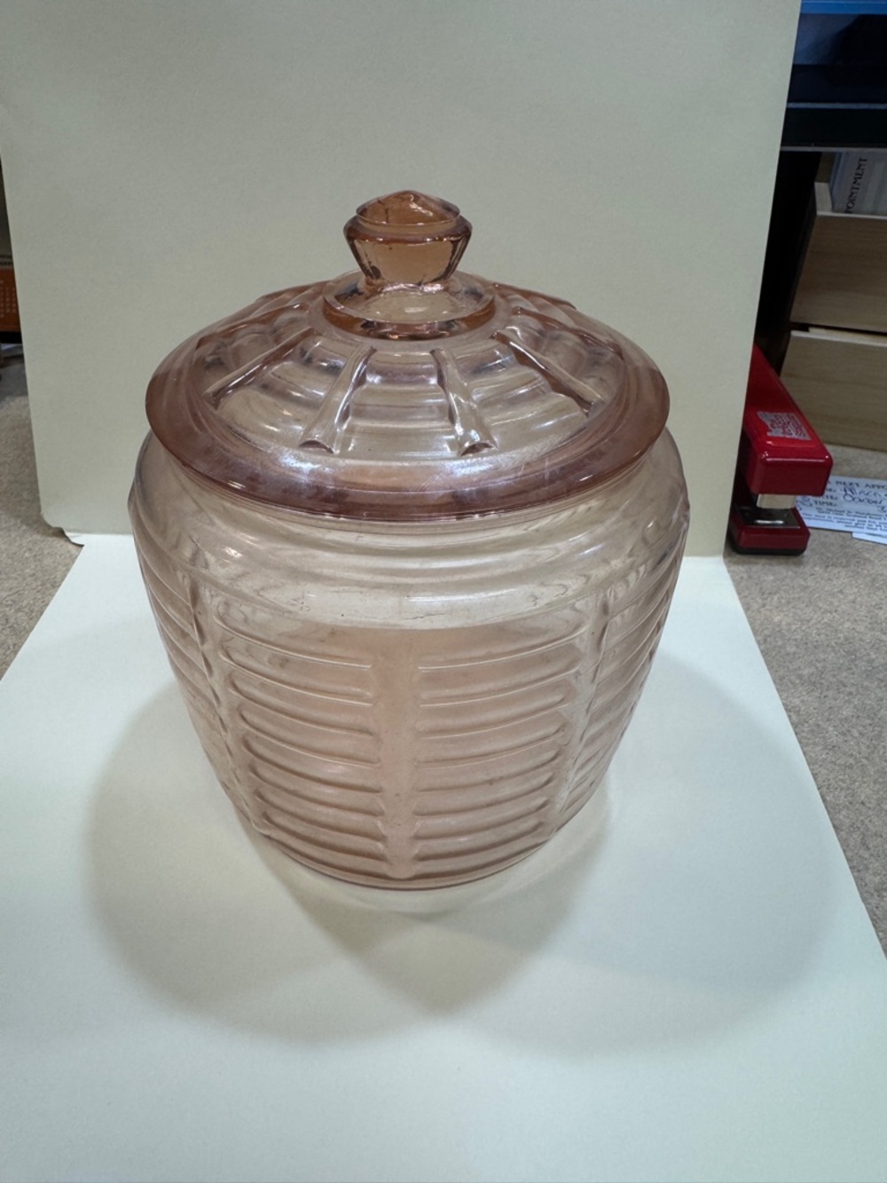 Pink Depression glass cookie jar with ribbed pattern and lid